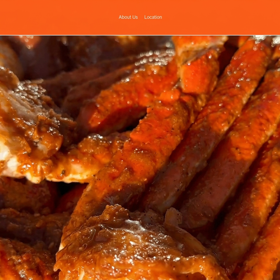 Close-up of a platter piled with bright orange crab legs and claws, glazed with sauce.